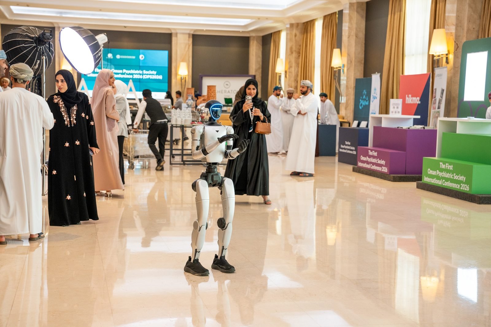 A humanoid robot greeting delegates in the OPS2026 foyer